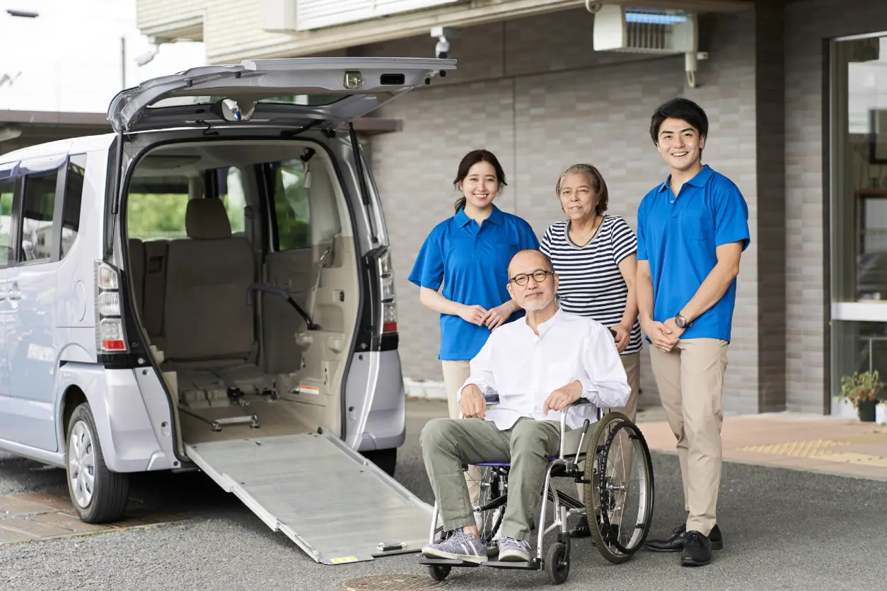 Caregivers with wheelchair-accessible van and senior man.